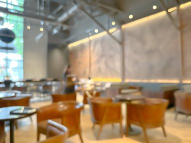 Ahşap sandalyeli, masalı, sıcak ışıklandırmalı ve büyük pencereli modern bir kafe.