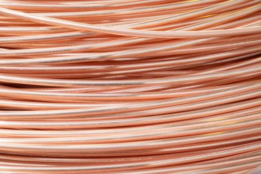 Parlak yüzeyi olan sarmalanmış bakır kabloların yakın çekimi, karmaşık örtüşen desenler, sıcak ışıklandırma..