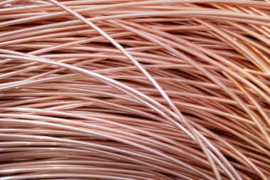 Parlak yüzeyi olan sarmalanmış bakır kabloların yakın çekimi, karmaşık örtüşen desenler, sıcak ışıklandırma..