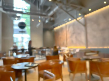 Ahşap sandalyeli, masalı, sıcak ışıklandırmalı ve büyük pencereli modern bir kafe.