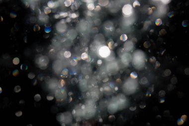 Siyah arkaplanda sudan gelen ışık bokeh