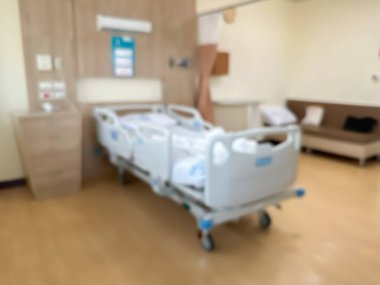 Lüks ve modern bir hasta odasındaki hastane yatağının bulanık görüntüsü. Atmosfer temiz ve etrafındaki manzarayı görebilirsiniz. Odanın etrafında pencereler var..