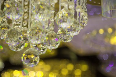 Güzel kristal avizeler. Sıcak ışık. Fırçalanmış cam kristallerin arasından yansıyan ışık.