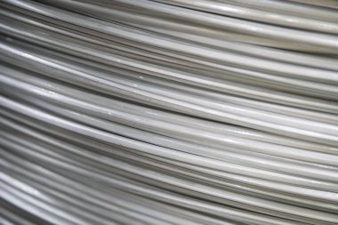 Pürüzsüz bir yüzeye sahip sarmal alüminyum kabloların yakın çekimi ve katmanlı örtüşen desen, yumuşak ışıklandırma.