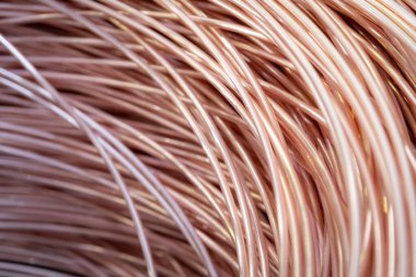 Parlak yüzeyi olan sarmalanmış bakır kabloların yakın çekimi, karmaşık örtüşen desenler, sıcak ışıklandırma..