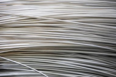 Pürüzsüz bir yüzeye sahip sarmal alüminyum kabloların yakın çekimi ve katmanlı örtüşen desen, yumuşak ışıklandırma.