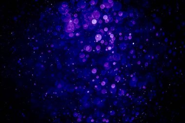 Bir fincan kahve ve şişeyle ön planda ahşap bir masa bulunan bulanık, modern kafe salonu.