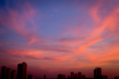 Gölge arkaplanda şehir olan gün batımının bulanık görüntüsü