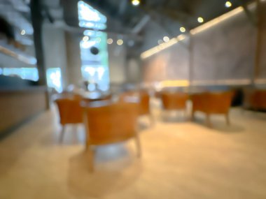 Ahşap sandalyeli, masalı, sıcak ışıklandırmalı ve büyük pencereli modern bir kafe.