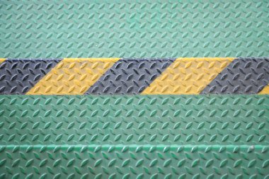 Green metal floor with diamond plate texture and a yellow and black hazard stripe in the center clipart