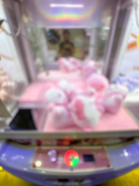 A colorful claw machine loaded with pink plush toys, inviting players to test their luck in a fun arcade environment. clipart