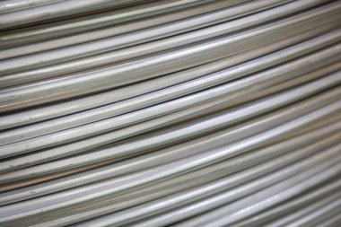 Pürüzsüz bir yüzeye sahip sarmal alüminyum kabloların yakın çekimi ve katmanlı örtüşen desen, yumuşak ışıklandırma.