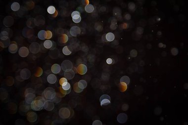 Karanlık arka planda renkli daireleri olan soyut sahte ışıklar, rüya gibi ve şenlikli bir atmosfer yaratıyor.