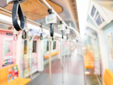 Parlak sarı koltukları ve paslanmaz çelik direkleriyle metro içi boş bir metro manzarası. Modern tren vagonu iyi ışıklandırılmış, üst kulpları ve pürüzsüz, temiz zeminleri var, hareket halindeki toplu taşımayı öneriyor..