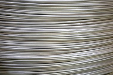 Pürüzsüz bir yüzeye sahip sarmal alüminyum kabloların yakın çekimi ve katmanlı örtüşen desen, yumuşak ışıklandırma.