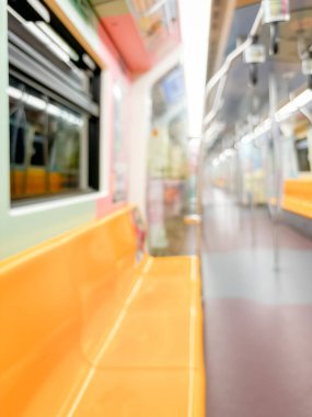 Parlak sarı koltukları ve paslanmaz çelik direkleriyle metro içi boş bir metro manzarası. Modern tren vagonu iyi ışıklandırılmış, üst kulpları ve pürüzsüz, temiz zeminleri var, hareket halindeki toplu taşımayı öneriyor..