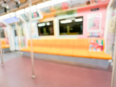 Parlak sarı koltukları ve paslanmaz çelik direkleriyle metro içi boş bir metro manzarası. Modern tren vagonu iyi ışıklandırılmış, üst kulpları ve pürüzsüz, temiz zeminleri var, hareket halindeki toplu taşımayı öneriyor..