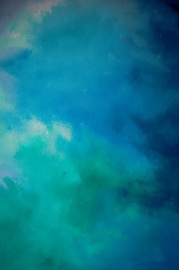 Mavi, mor ve yeşil renklerin dokulu görünümlü bir karışımını içeren soyut fırça darbesi resmi.