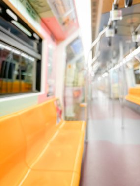 Parlak sarı koltukları ve paslanmaz çelik direkleriyle metro içi boş bir metro manzarası. Modern tren vagonu iyi ışıklandırılmış, üst kulpları ve pürüzsüz, temiz zeminleri var, hareket halindeki toplu taşımayı öneriyor..