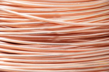 Parlak yüzeyi olan sarmalanmış bakır kabloların yakın çekimi, karmaşık örtüşen desenler, sıcak ışıklandırma..