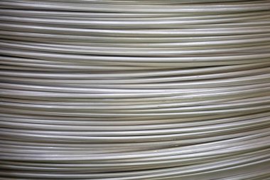 Pürüzsüz bir yüzeye sahip sarmal alüminyum kabloların yakın çekimi ve katmanlı örtüşen desen, yumuşak ışıklandırma.