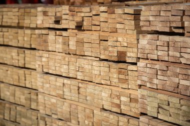 Kereste deposunda istiflenmiş ahşap kalaslar, çeşitli gölgeler ve dokular, düzenli bir şekilde düzenlenmiş..