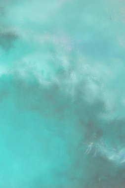 Mavi, mor ve yeşil renklerin dokulu görünümlü bir karışımını içeren soyut fırça darbesi resmi.