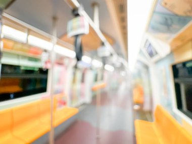 Parlak sarı koltukları ve paslanmaz çelik direkleriyle metro içi boş bir metro manzarası. Modern tren vagonu iyi ışıklandırılmış, üst kulpları ve pürüzsüz, temiz zeminleri var, hareket halindeki toplu taşımayı öneriyor..