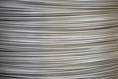 Pürüzsüz bir yüzeye sahip sarmal alüminyum kabloların yakın çekimi ve katmanlı örtüşen desen, yumuşak ışıklandırma.