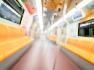 Parlak sarı koltukları ve paslanmaz çelik direkleriyle metro içi boş bir metro manzarası. Modern tren vagonu iyi ışıklandırılmış, üst kulpları ve pürüzsüz, temiz zeminleri var, hareket halindeki toplu taşımayı öneriyor..