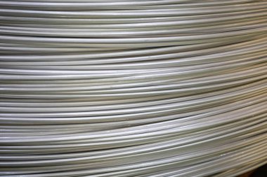 Pürüzsüz bir yüzeye sahip sarmal alüminyum kabloların yakın çekimi ve katmanlı örtüşen desen, yumuşak ışıklandırma.