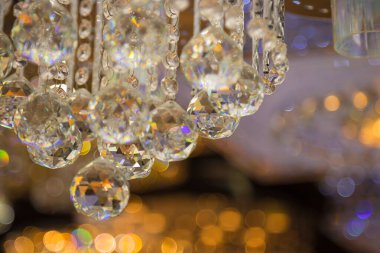 Güzel kristal avizeler. Sıcak ışık. Fırçalanmış cam kristallerin arasından yansıyan ışık.