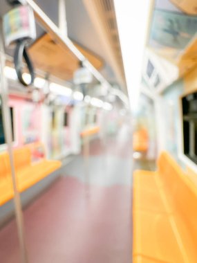 Parlak sarı koltukları ve paslanmaz çelik direkleriyle metro içi boş bir metro manzarası. Modern tren vagonu iyi ışıklandırılmış, üst kulpları ve pürüzsüz, temiz zeminleri var, hareket halindeki toplu taşımayı öneriyor..