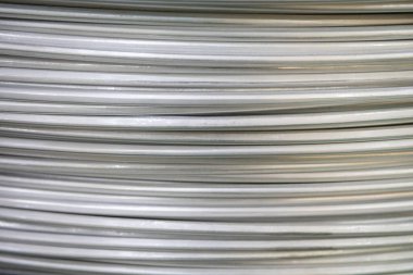 Pürüzsüz bir yüzeye sahip sarmal alüminyum kabloların yakın çekimi ve katmanlı örtüşen desen, yumuşak ışıklandırma.