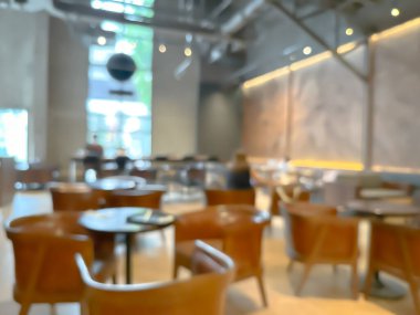 Ahşap sandalyeli, masalı, sıcak ışıklandırmalı ve büyük pencereli modern bir kafe.