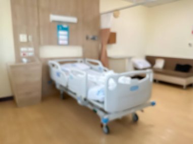 Lüks ve modern bir hasta odasındaki hastane yatağının bulanık görüntüsü. Atmosfer temiz ve etrafındaki manzarayı görebilirsiniz. Odanın etrafında pencereler var..