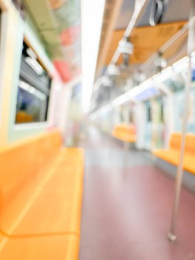 Parlak sarı koltukları ve paslanmaz çelik direkleriyle metro içi boş bir metro manzarası. Modern tren vagonu iyi ışıklandırılmış, üst kulpları ve pürüzsüz, temiz zeminleri var, hareket halindeki toplu taşımayı öneriyor..