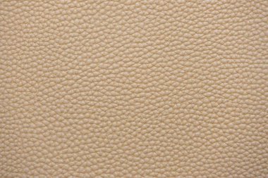 Yumuşak, kremsi deri dokusunun yakın çekimi. Yüzey küçük, eşit aralıklı tahıllarla kaplı, pürüzsüz ve lüks bir görünüm sağlıyor. Nötr renk ve doğal doku onu çok yönlü bir arkaplan yapar.