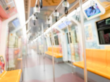 Parlak sarı koltukları ve paslanmaz çelik direkleriyle metro içi boş bir metro manzarası. Modern tren vagonu iyi ışıklandırılmış, üst kulpları ve pürüzsüz, temiz zeminleri var, hareket halindeki toplu taşımayı öneriyor..