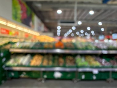 Raflarda çeşitli taze meyve ve sebzelerin sergilendiği bir market üretim bölümünün bulanık görüntüsü. Resim ürünün canlı renklerini ve dokularını yakalar