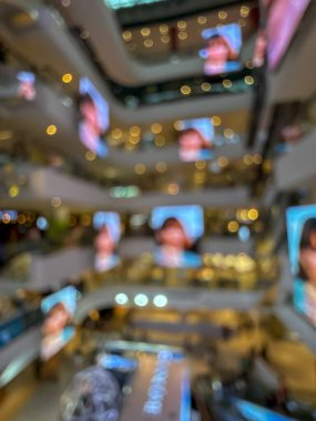 Hareketli bir alışveriş merkezinin bulanık görüntüsü modern bir perakende satış ortamının canlı atmosferini yakalıyor. İnsanlar alışveriş yaparken görülüyor.