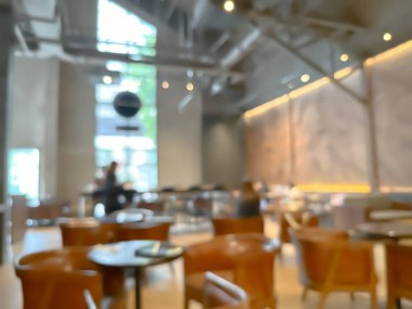 Ahşap sandalyeli, masalı, sıcak ışıklandırmalı ve büyük pencereli modern bir kafe.