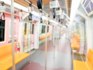 Parlak sarı koltukları ve paslanmaz çelik direkleriyle metro içi boş bir metro manzarası. Modern tren vagonu iyi ışıklandırılmış, üst kulpları ve pürüzsüz, temiz zeminleri var, hareket halindeki toplu taşımayı öneriyor..