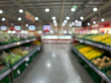 Raflarda çeşitli taze meyve ve sebzelerin sergilendiği bir market üretim bölümünün bulanık görüntüsü. Resim ürünün canlı renklerini ve dokularını yakalar