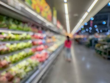 Raflarda çeşitli taze meyve ve sebzelerin sergilendiği bir market üretim bölümünün bulanık görüntüsü. Resim ürünün canlı renklerini ve dokularını yakalar