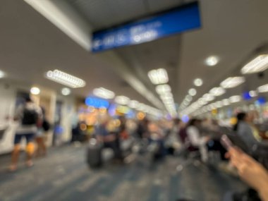 Havaalanının iç kısmının bulanık görüntüsü, hafif ışıklandırma, oturma alanları ve sakin, bastırılmış bir atmosferi var..