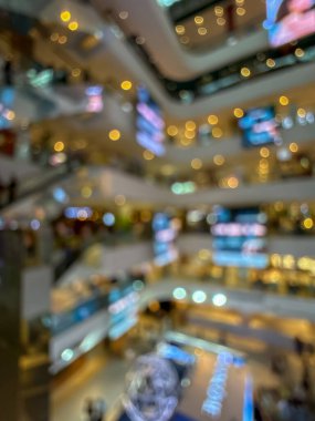 Hareketli bir alışveriş merkezinin bulanık görüntüsü modern bir perakende satış ortamının canlı atmosferini yakalıyor. İnsanlar alışveriş yaparken görülüyor.