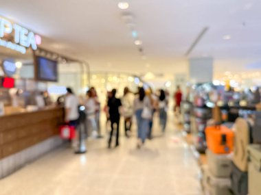 Hareketli bir alışveriş merkezinin bulanık görüntüsü modern bir perakende satış ortamının canlı atmosferini yakalıyor. İnsanlar alışveriş yaparken görülüyor.