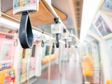 Parlak sarı koltukları ve paslanmaz çelik direkleriyle metro içi boş bir metro manzarası. Modern tren vagonu iyi ışıklandırılmış, üst kulpları ve pürüzsüz, temiz zeminleri var, hareket halindeki toplu taşımayı öneriyor..