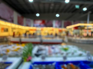 Raflarda çeşitli taze meyve ve sebzelerin sergilendiği bir market üretim bölümünün bulanık görüntüsü. Resim ürünün canlı renklerini ve dokularını yakalar